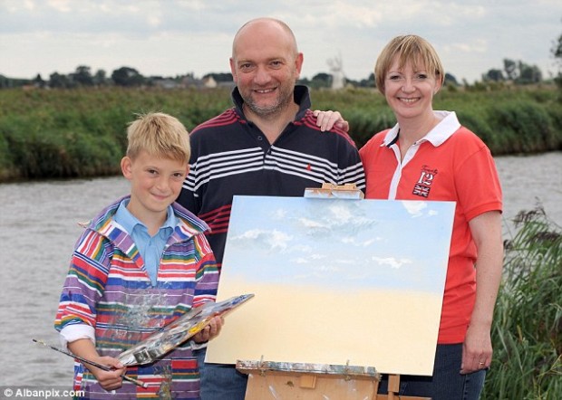 Proud parents: Ten-year-old Mini Monet Kieron Williamson next to a work in progress on the Norfolk broads with his mother Michelle and father Keith